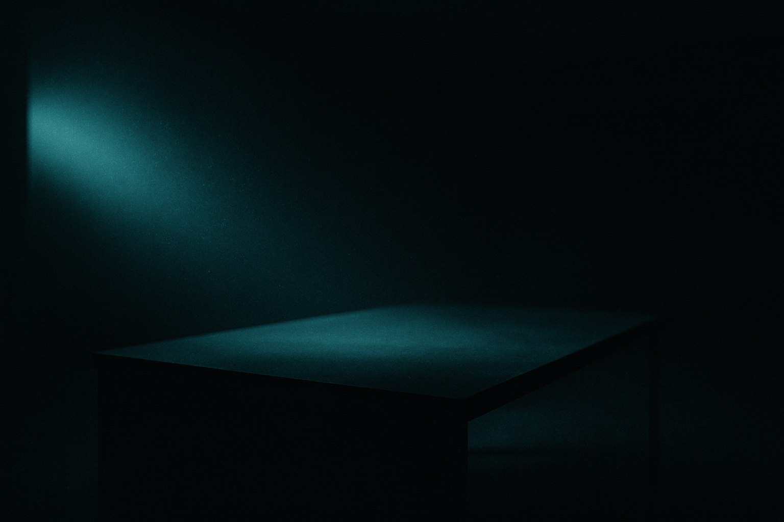 A single lit desk surface in a vast dark room